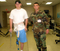 Chris Weaver assists a patient with gait training. He assists the patient in learning to walk with correct form and posture.