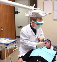 Christopher Beadle performs a routine tooth cleaning.