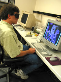 David Belnap wears special stereo glasses to  visualize 3-dimensional images on his computer monitor.