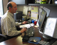 Dennis spends time at his computer, assessing current institute programs and identifying ways to improve their implementation.