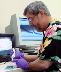 In the laboratory, Jack Simpson prepares to run a sample through the mass spectrometer for analysis.
