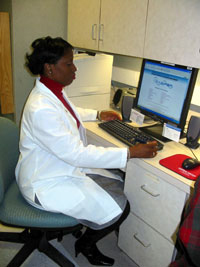Keisha Potter reviews patient laboratory results at her desk.