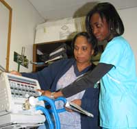 Kevilin reviews the basic settings on the T-Bird Ventilator with one of her supervisors, Lisa Zackery (Clinical Supervisor).