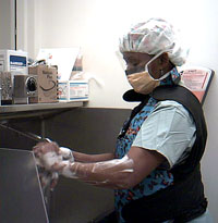 Lisa Brown scrubs her hands and arms in preparation for surgery. She will wear a sterile gown and gloves before setting-up instruments and supplies for the case.