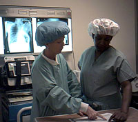 Lisa Brown gets an update on cases from her colleague Maureen George, while reviewing the surgery schedule.