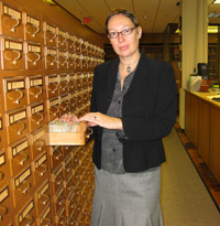 Manon sorts throught the card catalog to locate research material