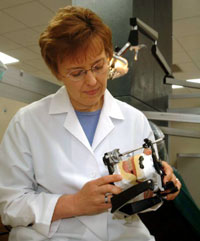 Mary Walker examines the tooth arrangement on an articulator that simulates patient jaw movements.