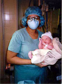 Matrice Browne holds a newborn that she has just delivered.