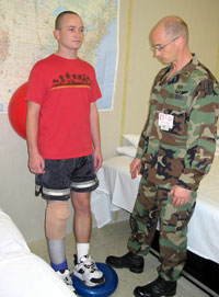 Matthew Scherer guides a patient through a balance exercise.