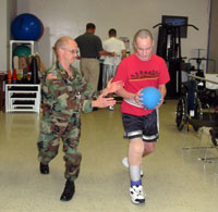 Matthew Scherer passes a ball to patient while running to increase strength and improve coordination.