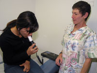 Phyllis Shipper assists in the use of a spirometer to measure air capacity in the lungs.