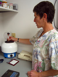 Phyllis Shipper uses a centrifuge to spin a blood sample for a laboratory test.