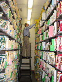 Ron DeClerck searches among the thousands of medical records in the Medical Record Deparment's filing system to retrieve a patient’s file.