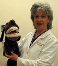 Sherri Gollins uses a puppet to teach oral hygiene to pediatric patients in the NIH Clinical Center.