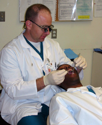 Stephen Sterlitz performs and oral exam on a patient.